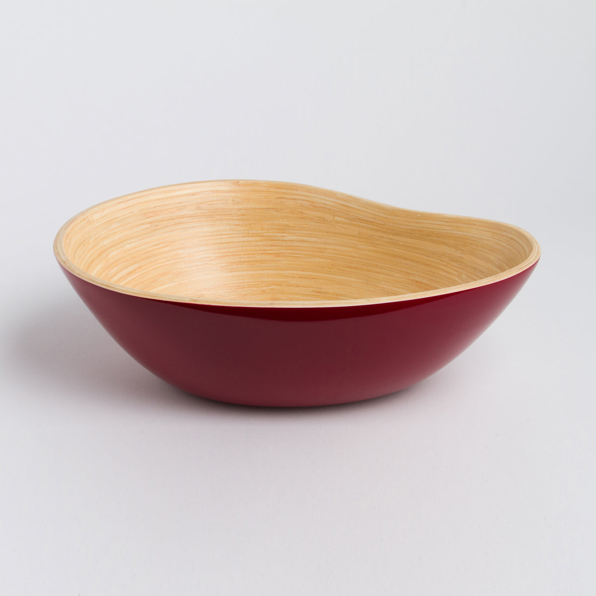 Red asymmetrical mango shaped bamboo serving bowl with a natural wood interior displayed on a light background for stylish home decor from DC-Bibol