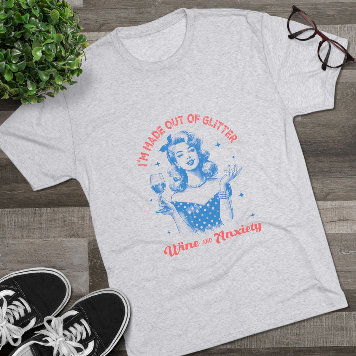 Light gray Printify graphic tee featuring a retro pinup woman holding a wine glass with blue and red text reading Im Made Out of Glitter Wine and Anxiety