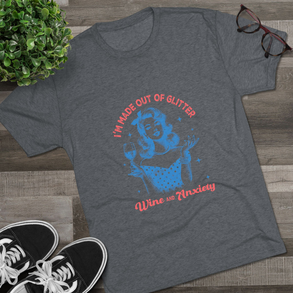 Gray Printify graphic tee featuring a retro pinup woman holding a wine glass with the phrase I am made out of glitter wine and anxiety for women's fashion