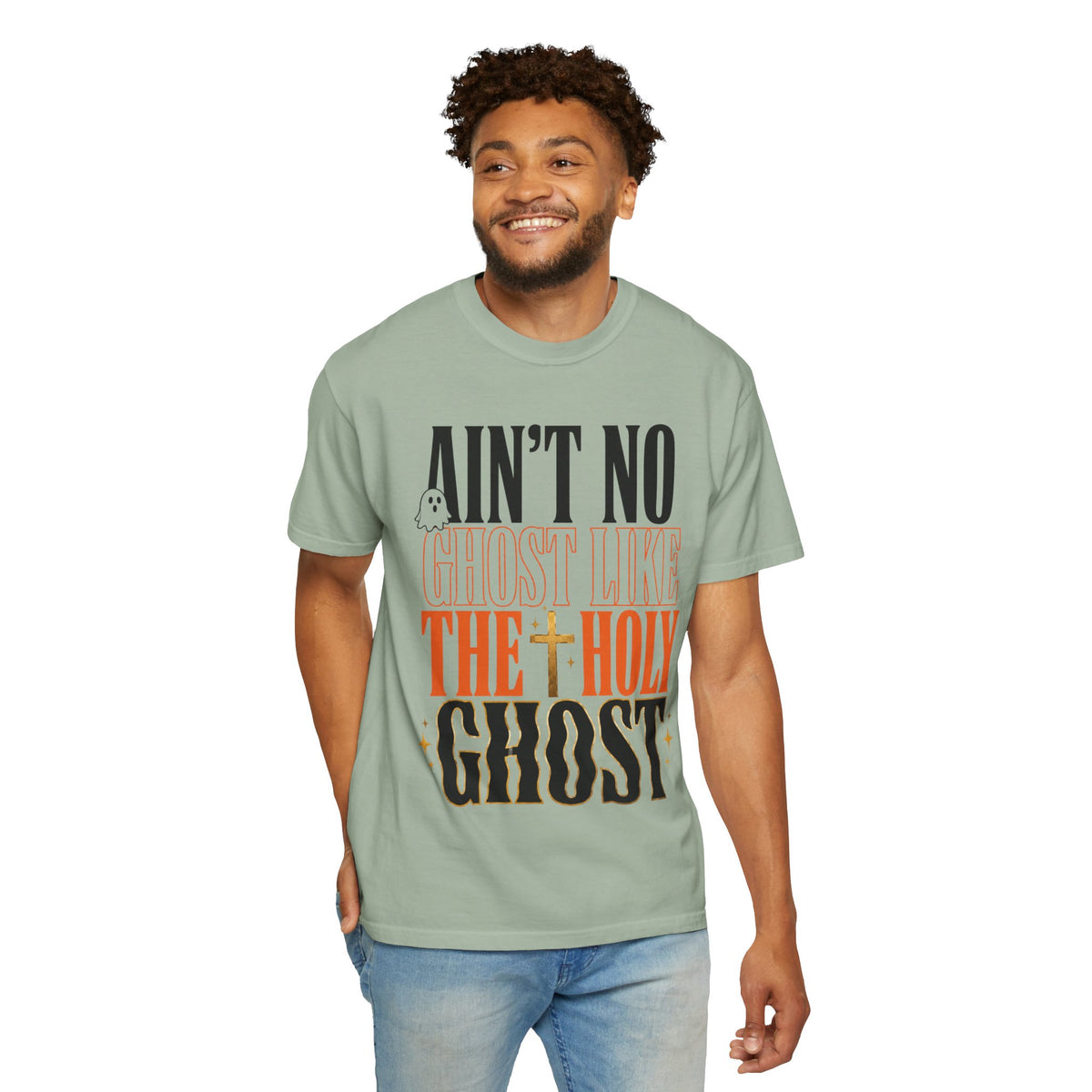 Smiling model wearing a sage green graphic T shirt with bold vintage lettering that reads Aint No Ghost Like the Holy Ghost in black orange and cream tones