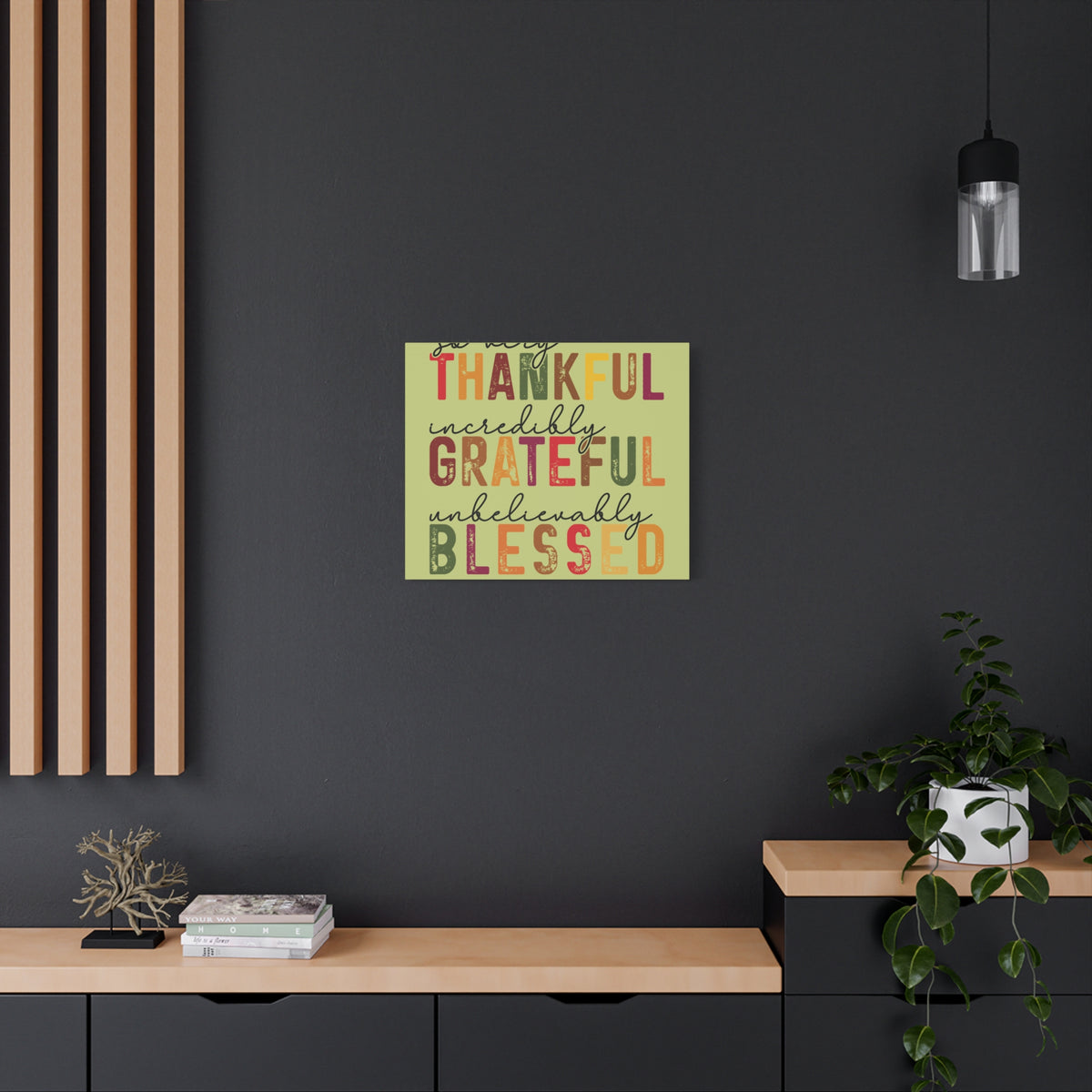 Autumn inspired matte canvas wall art with colorful distressed lettering reading Thankful Grateful Blessed displayed above a modern console in a dark room
