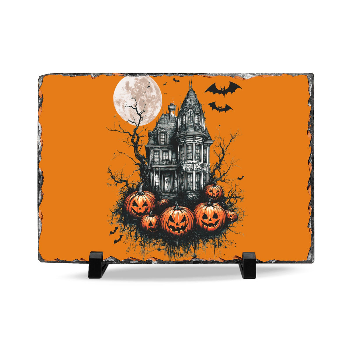 Halloween slate desk plaque with a haunted house under a full moon surrounded by bats and carved pumpkins on an orange background displayed on a stand