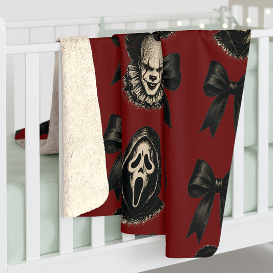 Red sherpa fleece blanket draped over a white railing with vintage horror masks and black bows on a dark red background for seasonal home decor
