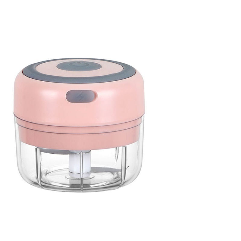 Pink mini electric garlic chopper with a transparent bowl, stainless steel blade, and simple push button design for quick food preparation