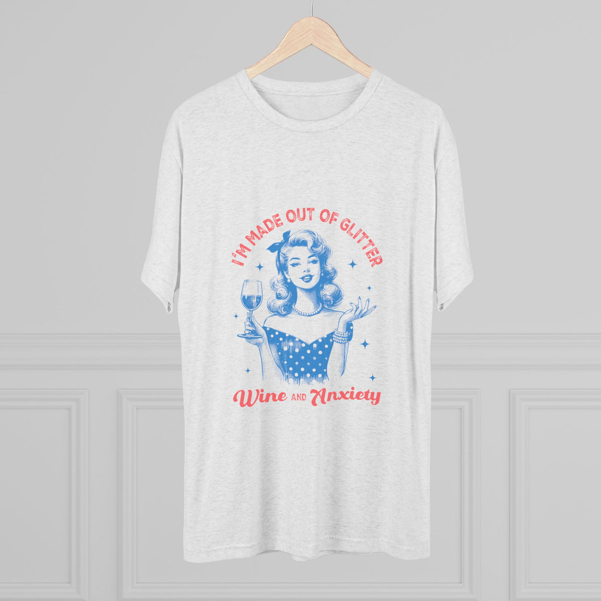 White graphic tee on a wooden hanger featuring a retro pinup woman with a wine glass and playful text reading Im Made Out of Glitter Wine and Anxiety