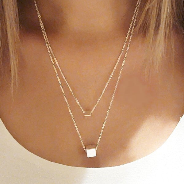 Silver double layer necklace with geometric cube pendants displayed on a model, creating a modern minimalist look for women's jewelry styling