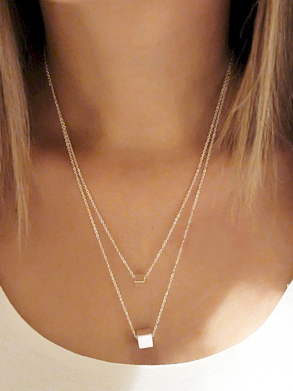 Woman wearing a silver double layer necklace with two geometric cube pendants in a modern minimalist style from Fashion Hut Jewelry in the Jewelry collection