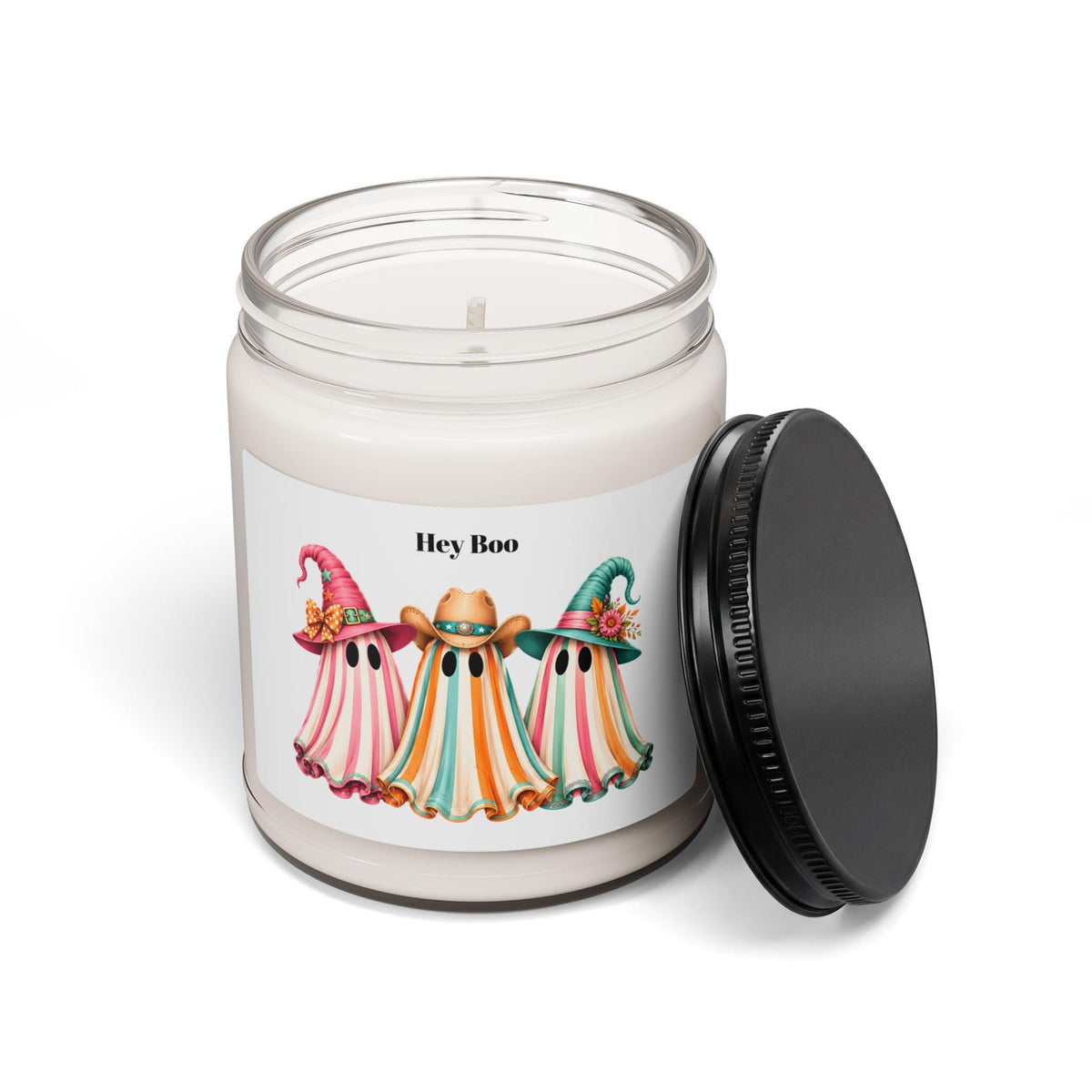 Scented soy candle in a clear glass jar with a black lid featuring three colorful ghost illustrations wearing cowboy hats for seasonal home decor