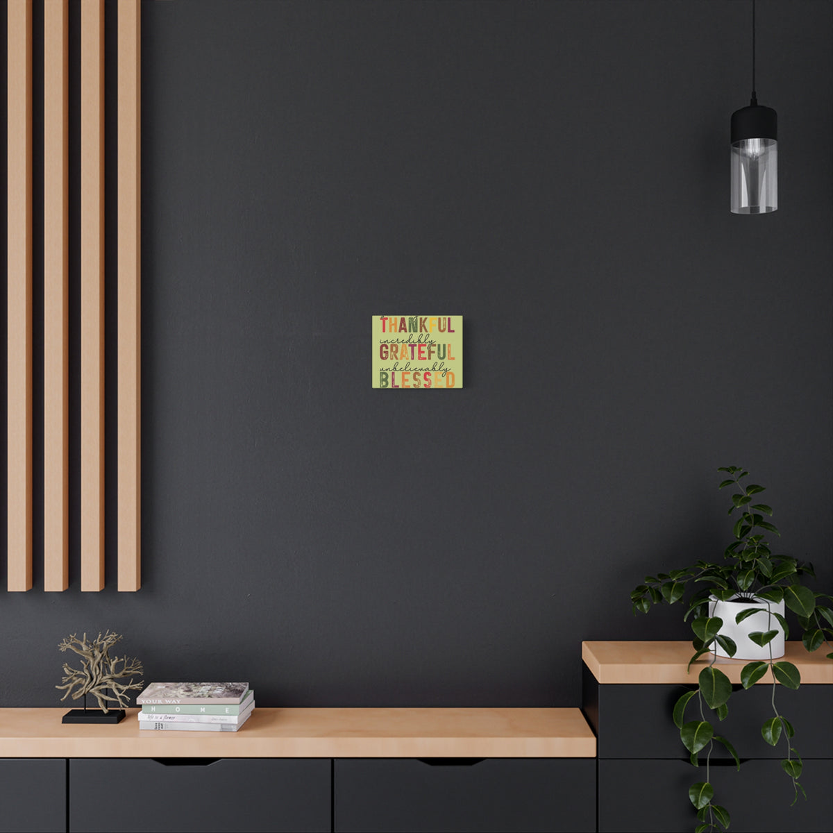 Thankful Grateful Blessed autumn wall art canvas displayed on a dark charcoal wall above a modern wood console with a plant and decor