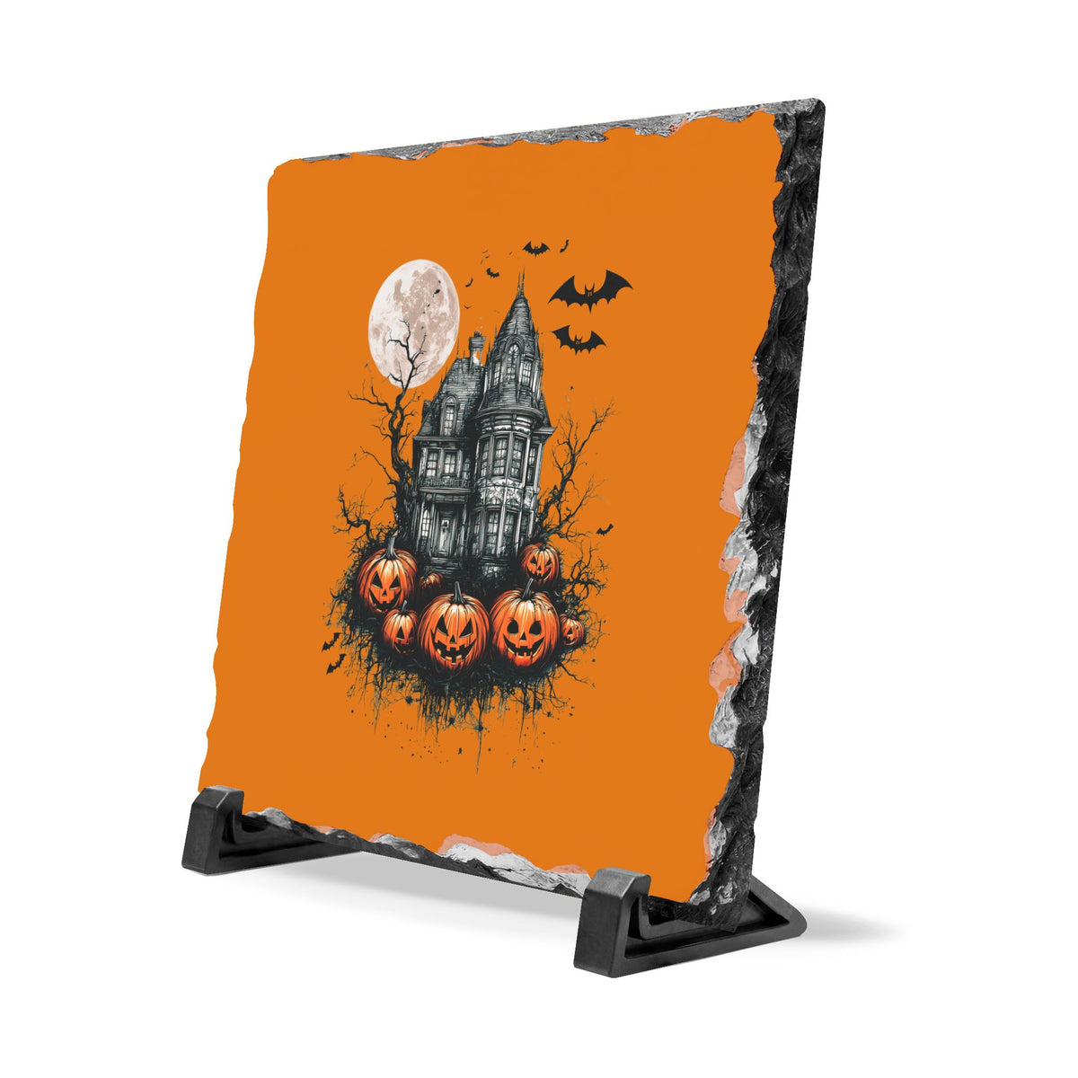 Halloween slate desk plaque with a vintage haunted house under a full moon with bats and glowing pumpkins on an orange background displayed on a black stand