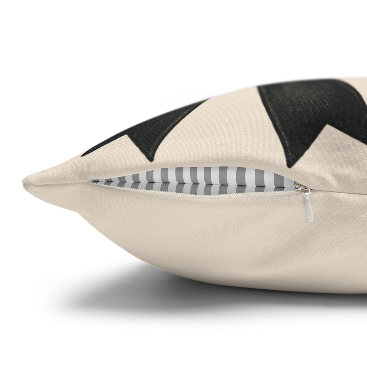 Cream decorative pillowcase with black bow pattern and a partially open zipper revealing striped lining for seasonal home decor