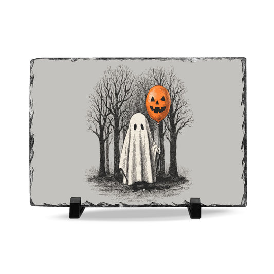Halloween slate desk plaque featuring a white sheet ghost holding an orange pumpkin balloon among bare trees on a gray stone background