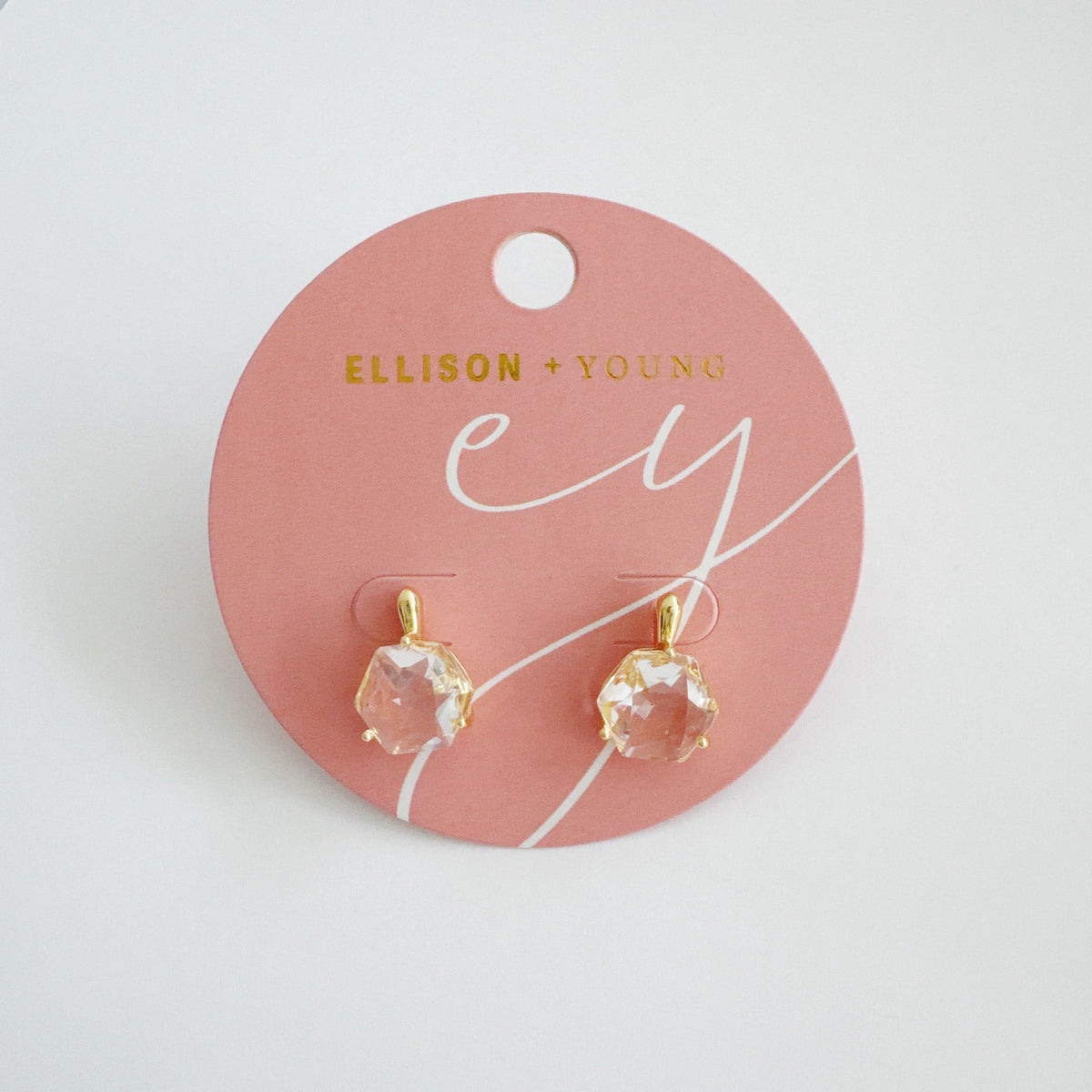 Faceted stone drop earrings with sculpted gold settings displayed on a blush Jewelry card from Ellison and Young for elegant women's jewelry styling