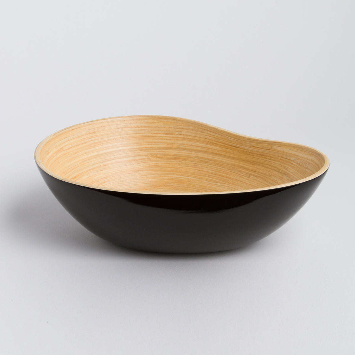 Asymmetrical bamboo serving bowl with a glossy black exterior and natural wood interior for serving or home decor from DC-Bibol in Home and beyond