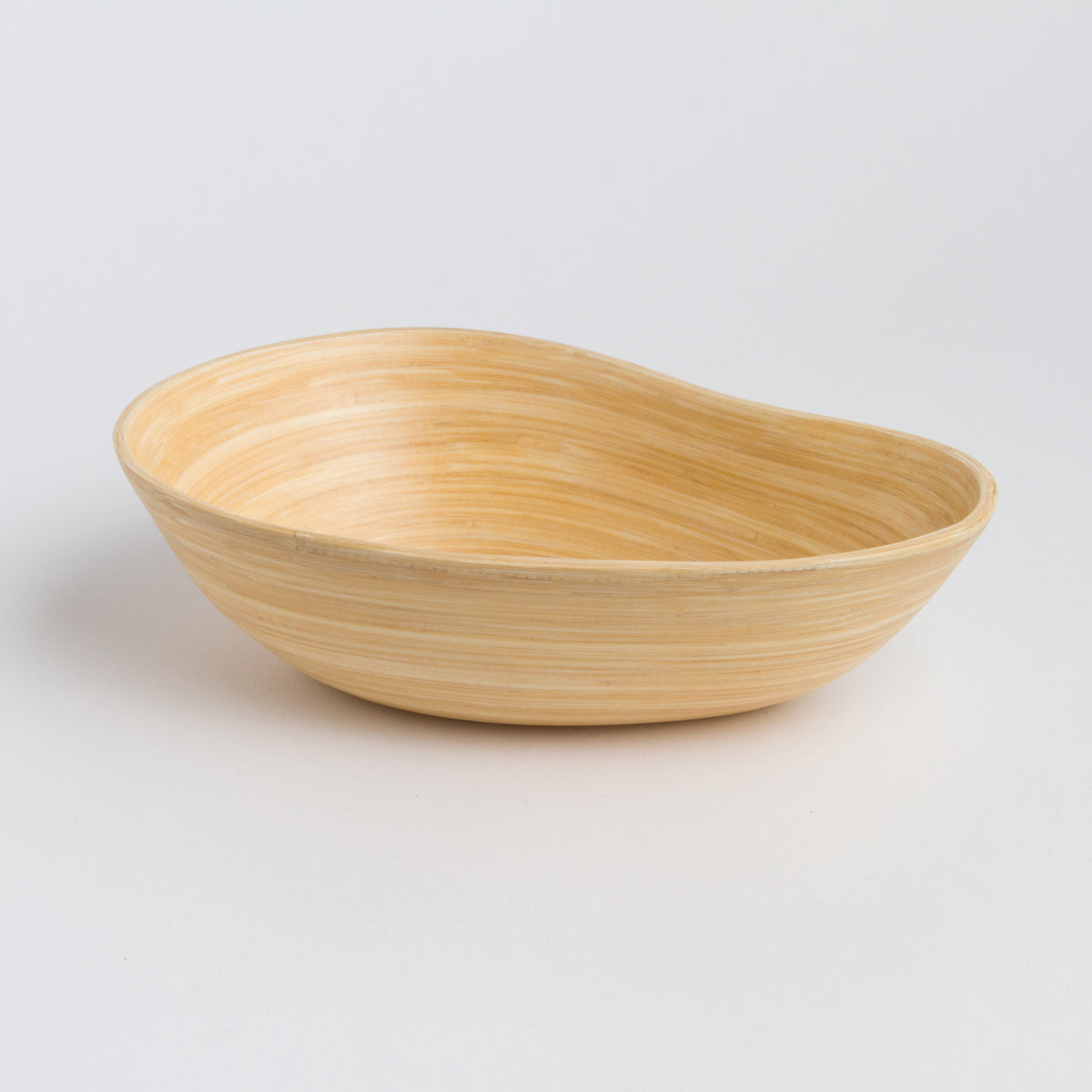 Natural bamboo serving bowl with a graceful asymmetrical mango shape for serving or home decor from DC Bibol in Home and beyond