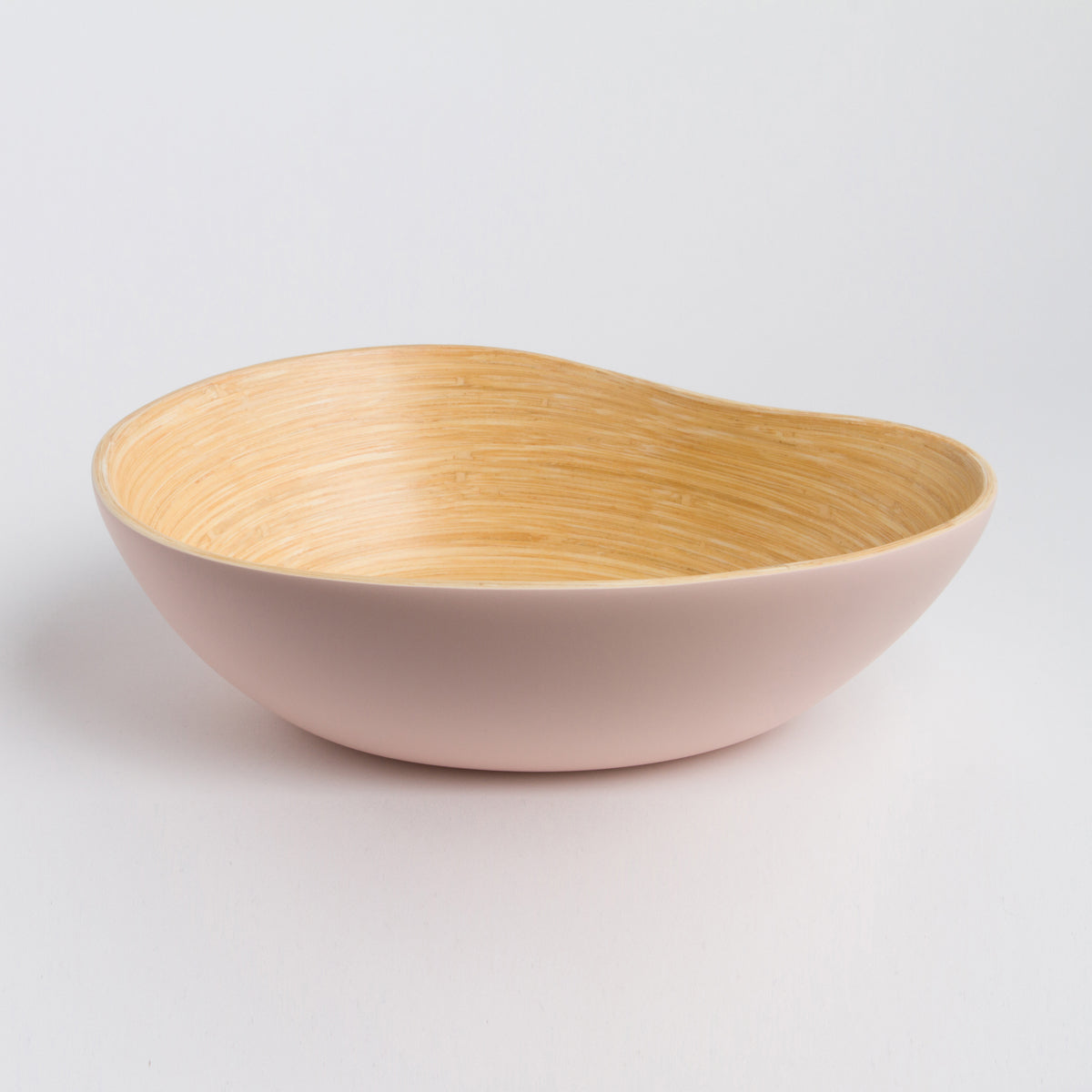 Bamboo mango shaped serving bowl with a natural woven interior and soft blush pink exterior styled as an elegant accent for home decor