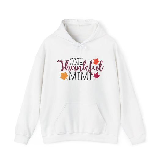 White cozy hooded sweatshirt featuring One Thankful Mimi lettering with colorful autumn leaves and a front pouch pocket for a festive fall look