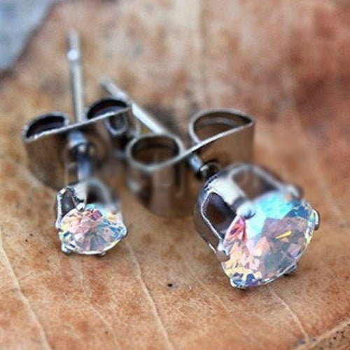 Pair of iridescent round cubic zirconia stud earrings with stainless steel backs displayed on a textured surface from Fashion Hut Jewelry Jewelry collection