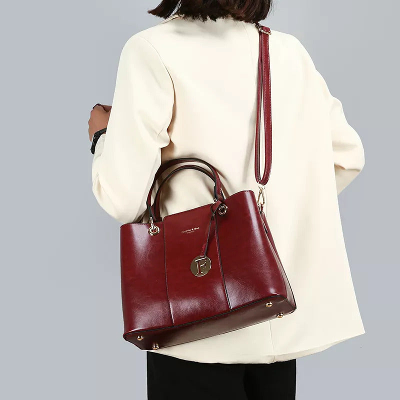 Maroon two piece womens handbag set with a structured tote and matching crossbody bag shown on a model from Savoy Active Bags and Belts collection
