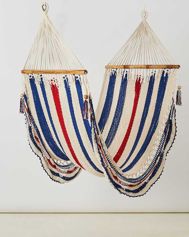 Two handmade cotton hammocks with wooden spreader bars in navy red and cream stripes hanging indoors from DC-Love for Nica home and beyond decor