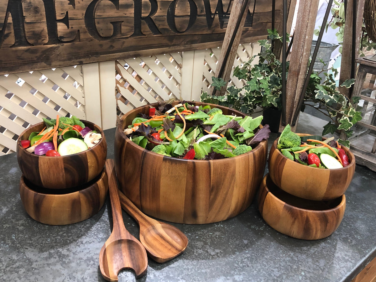 Wooden salad bowl set with a large serving bowl individual bowls and wooden servers filled with fresh salad from DC Kalmar Home in Home and beyond