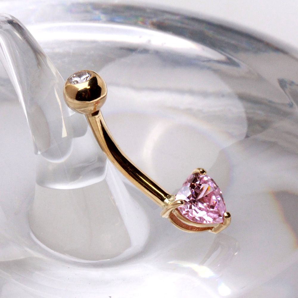 14kt gold navel ring featuring a prong set pink heart shaped cubic zirconia and polished gold ball detail from Fashion Hut Jewelry in the Jewelry collection