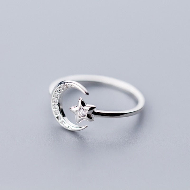 Adjustable sterling silver ring featuring a crescent moon and sparkling star with zircon accents in a graceful celestial design